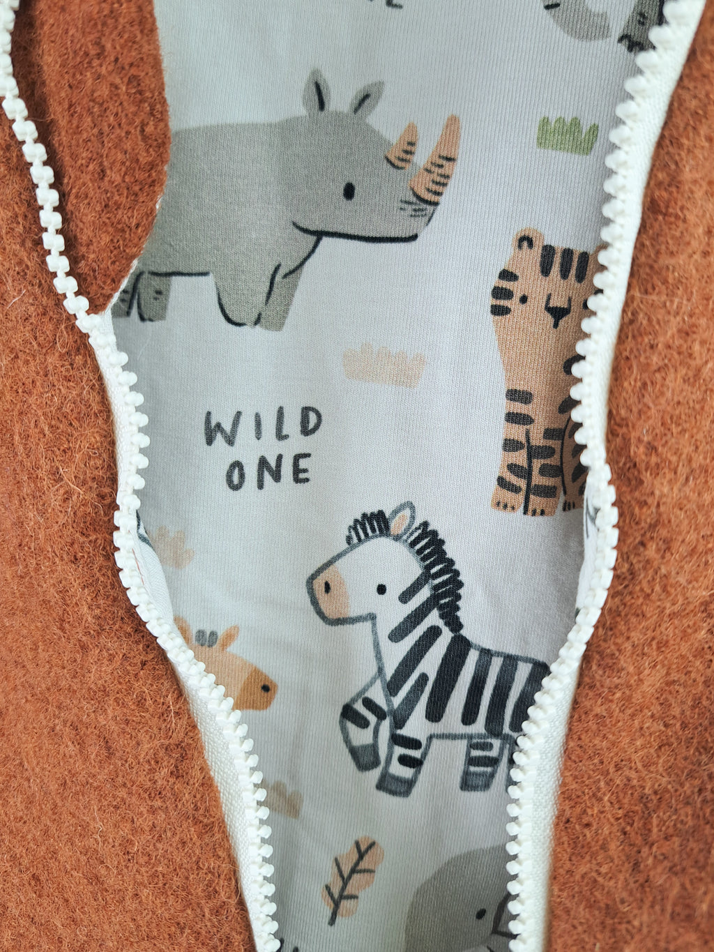 Rust-colored romper with wildlife print